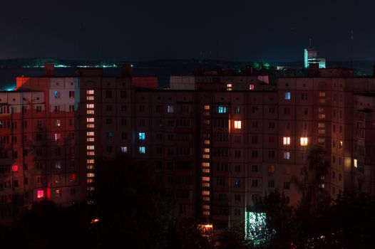 Night long exposure photo 9 and 10 floors high-rise buildings in red colours. Big city life is here!