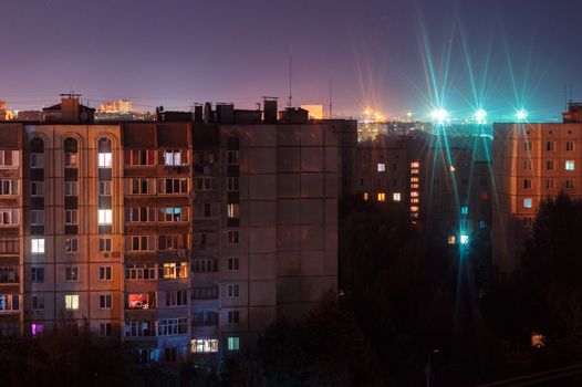 Night long exposure photo 9 and 10 floors high-rise buildings in orange and blue colours. Big city life is here!