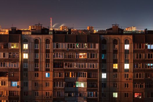 Night long exposure photo 9 and 10 floors high-rise buildings in orange colours. Big city life is here!