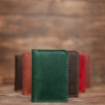 Soft focus photo of green colour handmade leather cardholder. Blurred background on photo. Different colour cardholders blurred on background.