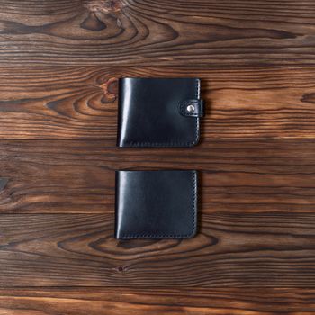Blue handmade leather gloss wallets on wooden textured background. Up to down view. Businessman wallet stock photo.