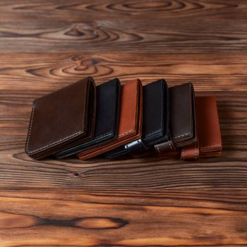 Six handmade leather wallets on wooden textured background. closeup. Wallet stock photo.