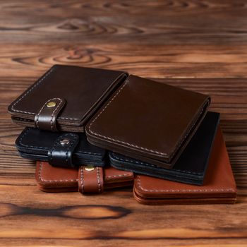 Six handmade leather wallets on wooden textured background. closeup. Wallet stock photo.