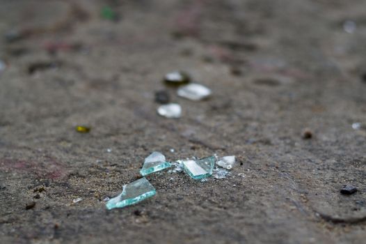 Broken glass bottles on white sand. Trash on the sand. Ecological problem.
