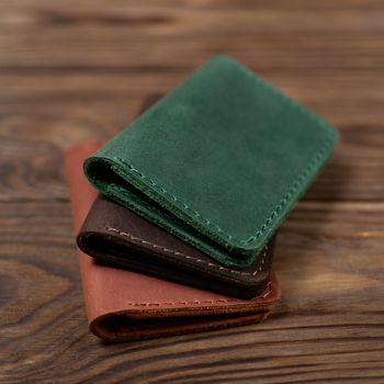 Three two-pocket leather handmade cardholder. Cardholders lies one on another. Stock photo on blurred background.