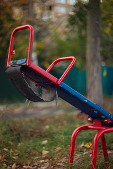 Baby swing in the fall in the park in wet weather