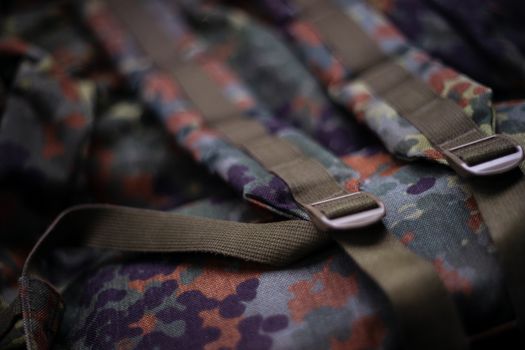 Military camouflage roomy backpack. In the frame of the strap and the back of a backpack. Close-up view.