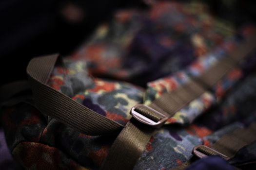Military camouflage roomy backpack. In the frame of the strap and the back of a backpack. Close-up view.