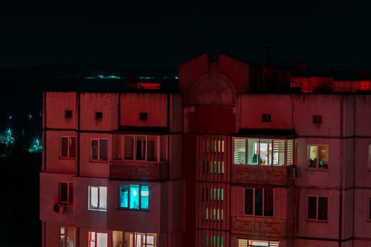 Long exposure photo of high-rise buildings in red and blue lights. Night cityscape. Big city life.