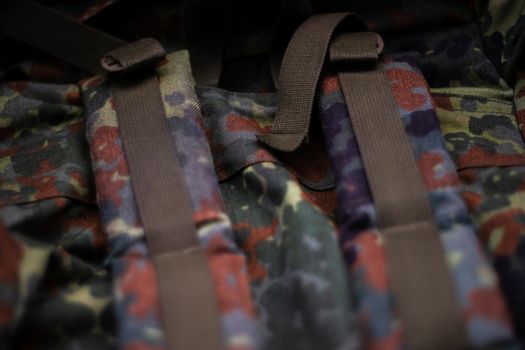 Military camouflage roomy backpack. In the frame of the strap and the back of a backpack. Close-up view.