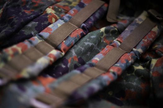 Military camouflage roomy backpack. In the frame of the strap and the back of a backpack. Close-up view.