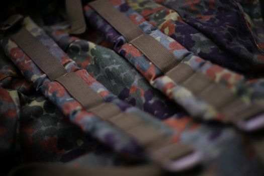 Military camouflage roomy backpack. In the frame of the strap and the back of a backpack. Close-up view.