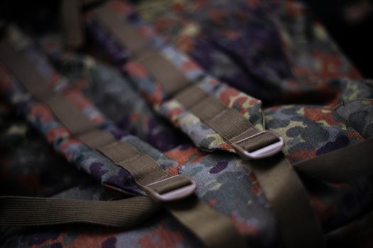 Military camouflage roomy backpack. In the frame of the strap and the back of a backpack. Close-up view.