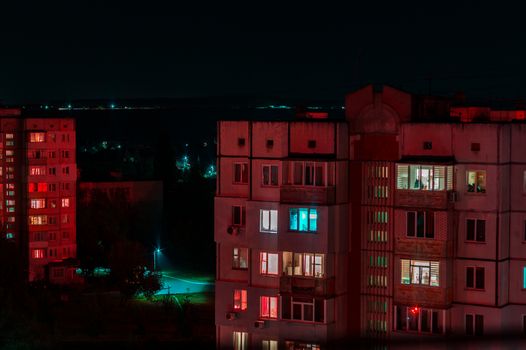 Long exposure photo of high-rise buildings in red and blue lights. Night cityscape. Big city life.