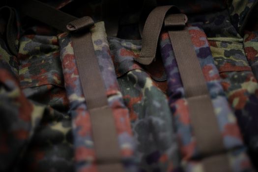 Military camouflage roomy backpack. In the frame of the strap and the back of a backpack. Close-up view.