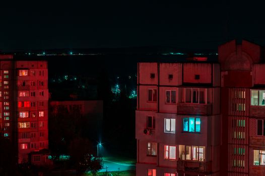 Long exposure photo of high-rise buildings in red and blue lights. Night cityscape. Big city life.