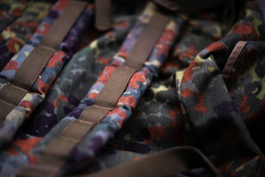 Military camouflage roomy backpack. In the frame of the strap and the back of a backpack. Close-up view.