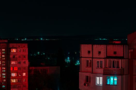 Long exposure photo of high-rise buildings in red and blue lights. Night cityscape. Big city life.