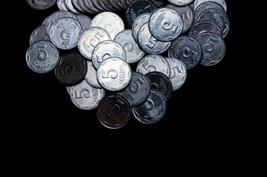Ukrainian coins isolated on black background. Close-up view. Coins are located above the center of frame. A conceptual image.