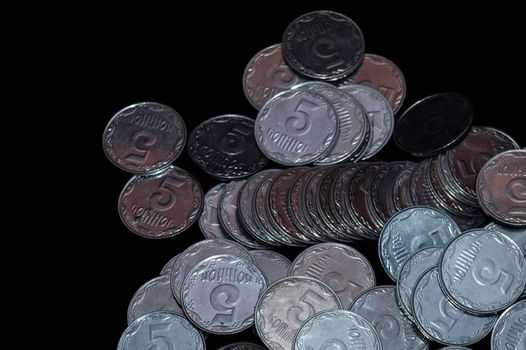 Small Ukrainian coins isolated on black background. Close-up view.