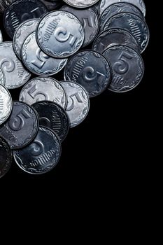 Ukrainian coins isolated on black background. Close-up view. Coins are located above the center of frame. A conceptual image.