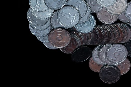 Small Ukrainian coins isolated on black background. Close-up view.