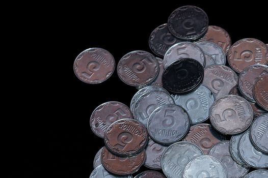 Small Ukrainian coins isolated on black background. Close-up view.