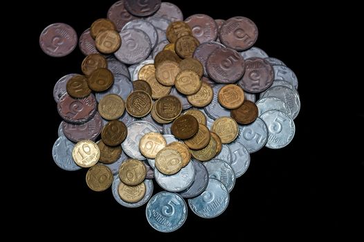 Small Ukrainian coins isolated on black background. Close-up view.