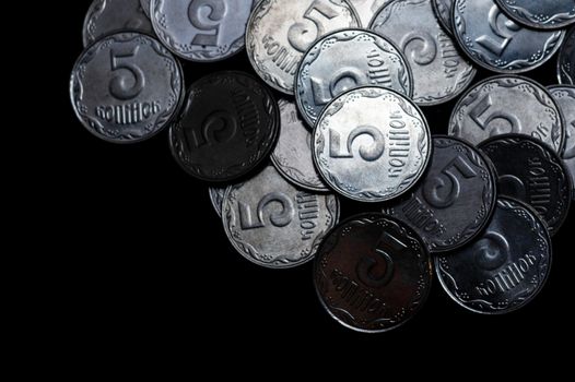 Ukrainian coins isolated on black background. Close-up view. Coins are located above the right side of frame. A conceptual image.