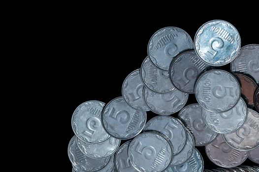 Small Ukrainian coins isolated on black background. Close-up view.