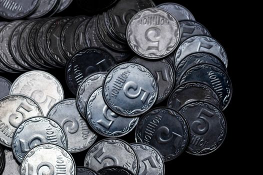Ukrainian coins isolated on black background. Close-up view. Coins are located above the left side of frame. A conceptual image.