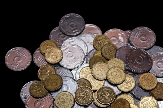 Small Ukrainian coins isolated on black background. Close-up view.