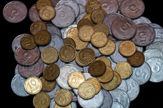 Small Ukrainian coins isolated on black background. Close-up view.