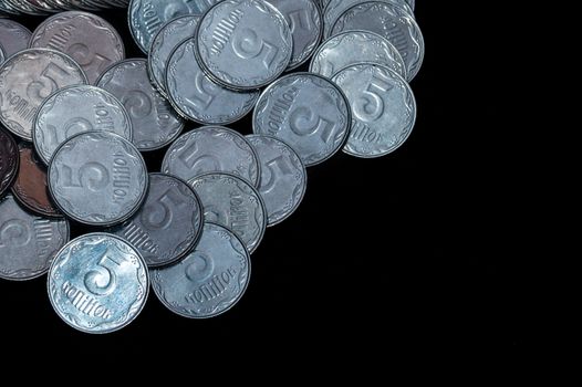 Small Ukrainian coins isolated on black background. Close-up view.