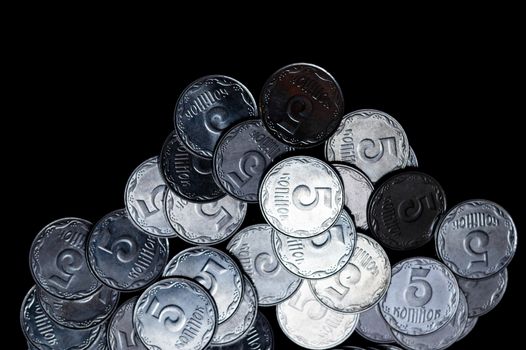 Ukrainian coins isolated on black background. Close-up view. Coins are located below the center of frame. A conceptual image.