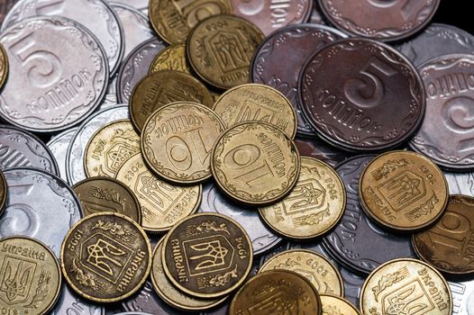 Small Ukrainian coins isolated on black background. Close-up view.