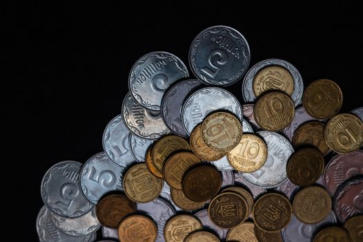 Small Ukrainian coins isolated on black background. Close-up view.