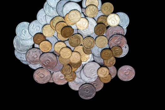 Small Ukrainian coins isolated on black background. Close-up view.