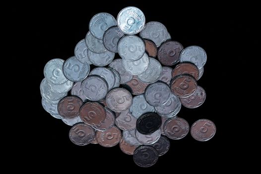 Small Ukrainian coins isolated on black background. Close-up view.