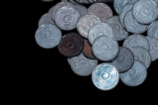 Small Ukrainian coins isolated on black background. Close-up view.