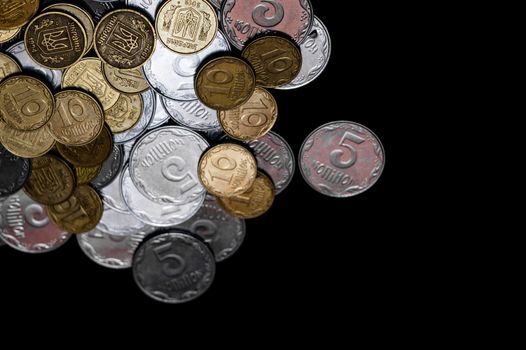 Ukrainian coins isolated on black background. Close-up view. Coins are located left-upper corner of image. A conceptual image.
