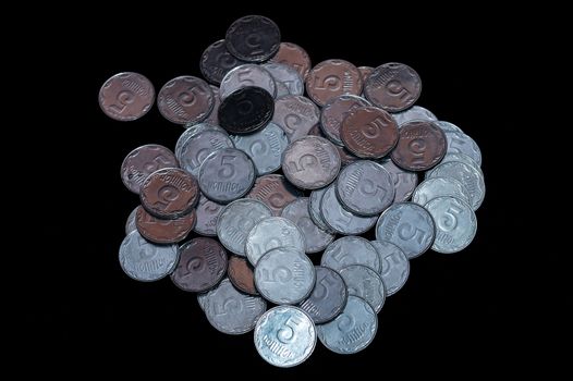Small Ukrainian coins isolated on black background. Close-up view.