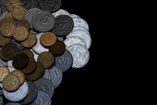 Ukrainian coins isolated on black background. Close-up view. Coins are located at the left side of frame. A conceptual image.