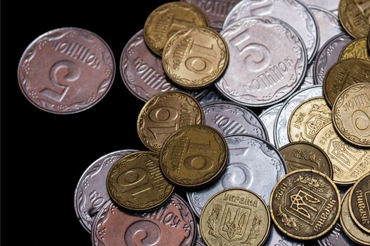 Small Ukrainian coins isolated on black background. Close-up view.
