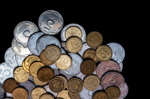 Small Ukrainian coins isolated on black background. Close-up view.