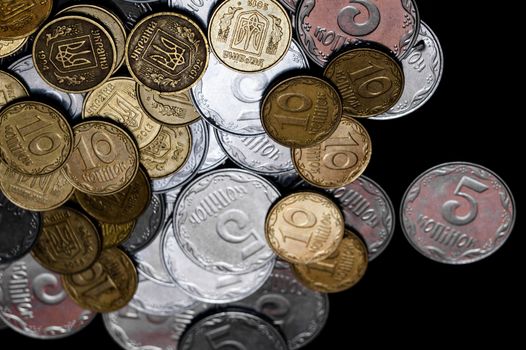 Ukrainian coins isolated on black background. Close-up view. Coins are located at the left side of frame. A conceptual image.
