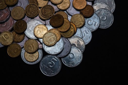 Small Ukrainian coins isolated on black background. Close-up view.