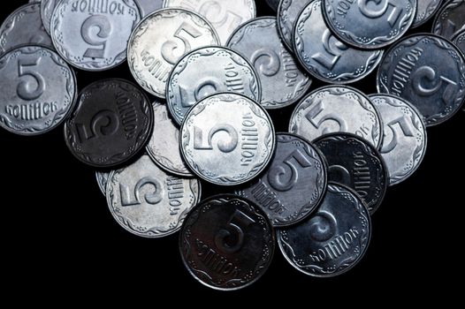 Ukrainian coins isolated on black background. Close-up view. Coins are located above the center of frame. A conceptual image.