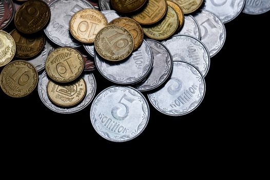 Ukrainian coins isolated on black background. Close-up view. Coins are located above the center of frame. A conceptual image.