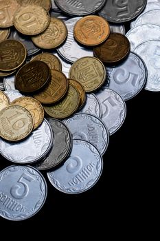 Ukrainian coins isolated on black background. Close-up view. Coins are located left-upper corner of image. A conceptual image.